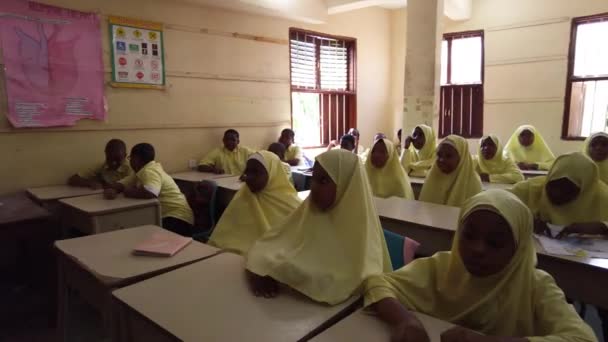 Kinderen in een Afrikaanse basisschool zitten aan een bureau in een klaslokaal, Zanzibar — Stockvideo