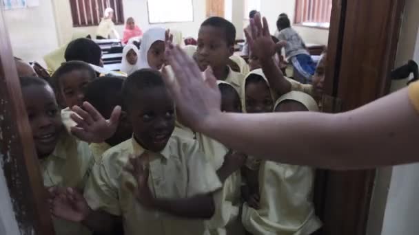 Multitud de niños africanos miran a una cámara dentro de una escuela primaria, Zanzíbar — Vídeos de Stock