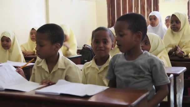 Děti v africké základní škole sedí za stolem ve třídě, Zanzibar — Stock video