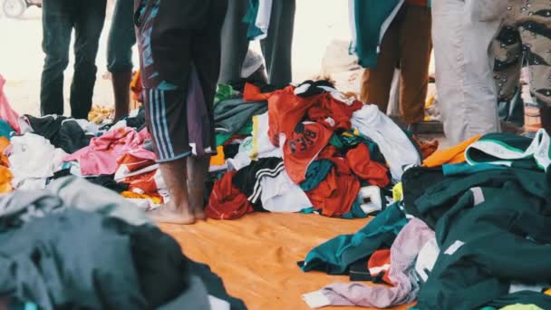 Africanos compran ropa de segunda mano en una tienda al aire libre en África, Zanzíbar — Vídeo de stock