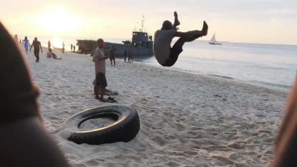 Místní afričtí teenageři uspořádat akrobatickou show na pláži při západu slunce, Zanzibar — Stock video