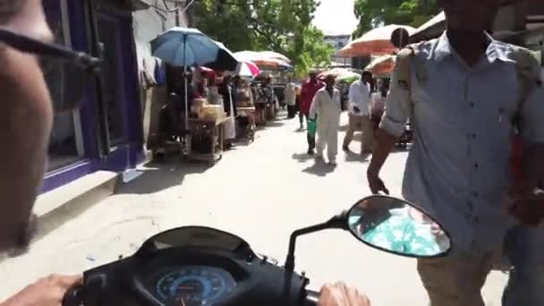 Monter un scooter par étroites rues sales de Stone Town avec les pauvres Africains — Video