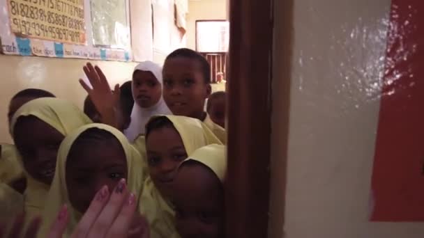 Menigte Afrikaanse kinderen kijken in een camera in een basisschool, Zanzibar — Stockvideo