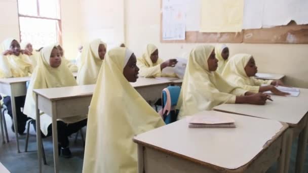 Kinderen in een Afrikaanse basisschool zitten aan een bureau in een klaslokaal, Zanzibar — Stockvideo