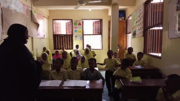 Gyerekek egy afrikai általános iskolában Üljenek asztalhoz egy osztályteremben, Zanzibárban. — Stock videók