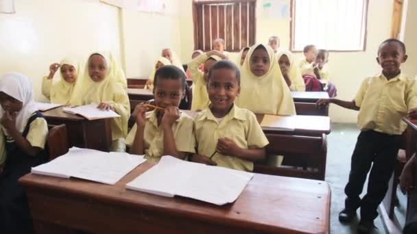 Kinder in einer afrikanischen Grundschule sitzen an Schreibtischen in einem Klassenzimmer, Sansibar — Stockvideo