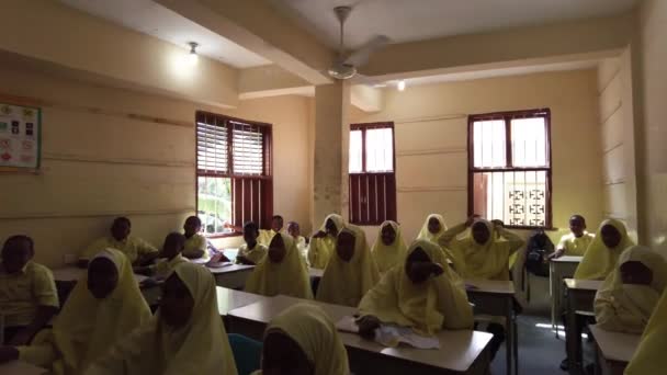 Gyerekek egy afrikai általános iskolában Üljenek asztalhoz egy osztályteremben, Zanzibárban. — Stock videók