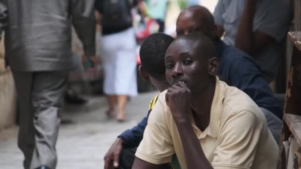 Smutný Afričan sedí na chudé ulici, místní černoch, smutný pohled, kamenné město, Zanzibar — Stock video