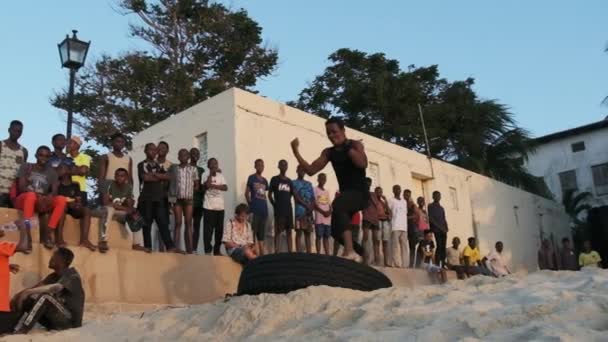 지역 아프리카 십 대 청소년들 이 잔지 바르의 선셋 해변에서 곡예 쇼를 진행하다 — 비디오