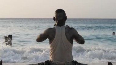 Atletik Afrikalı Adam Twine 'ın üzerine oturdu ve Okyanus kıyısındaki spor için sahile gitti.