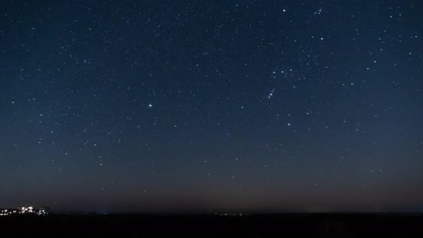 Ο έναστρος ουρανός τη νύχτα περιστρέφεται πάνω από τον ορίζοντα κοντά στην πόλη, Timelapse — Αρχείο Βίντεο