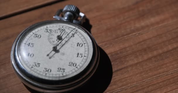 Μια αντίκα χρονόμετρο βρίσκεται στο ξύλινο τραπέζι και μετρά τα δευτερόλεπτα — Αρχείο Βίντεο