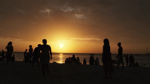 Silhouette di persone che giocano a beach volley al tramonto, rallentatore, Zanzibar — Video Stock