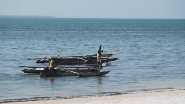 Pescadores africanos en el viejo barco de madera Dhow flotando empujando apagado con palos largos — Vídeos de Stock