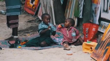 Yerel Afrikalı Kirli Oğlan ve Kız Yerde Oturur, Oynar ve Gülümser, Zanzibar