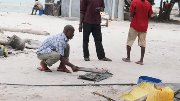 Místní afričtí rybáři bijí čerstvé chobotnice kus dřeva na rybím trhu — Stock video