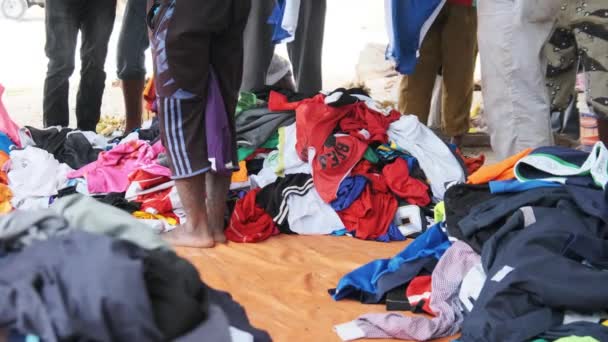 Afrykańczycy kupują używane ubrania w sklepie na świeżym powietrzu w Afryce, Zanzibar — Wideo stockowe