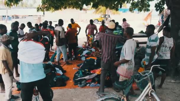 Afrikai emberek használt ruhát vesznek egy szabadtéri boltban Afrikában, Zanzibárban — Stock videók