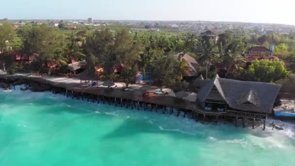 Tropische Landschaft von Sansibar, Wellen treffen Riff an Hotelküste mit Palmen — Stockvideo