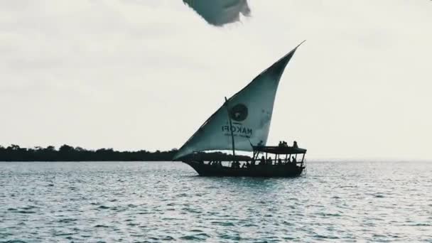 Dhow tradicional barco africano com turistas flutua sob a vela aberta pelo oceano — Vídeo de Stock