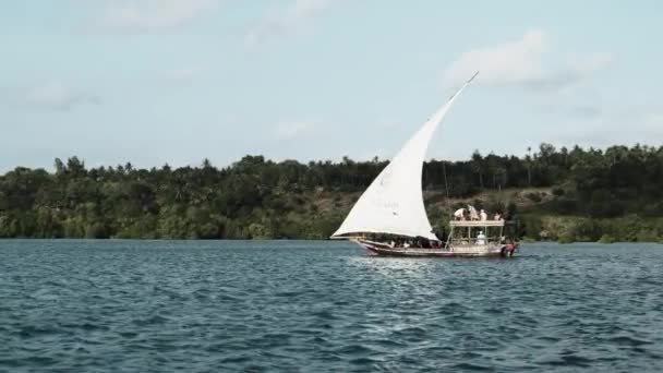 Dhow tradicional barco africano com turistas flutua sob a vela aberta pelo oceano — Vídeo de Stock