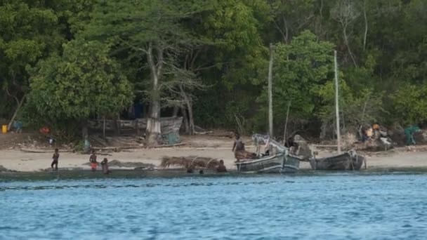 Village de pêcheurs africains locaux, les habitants déchargent le bateau de pêche Dhow au large de la côte — Video