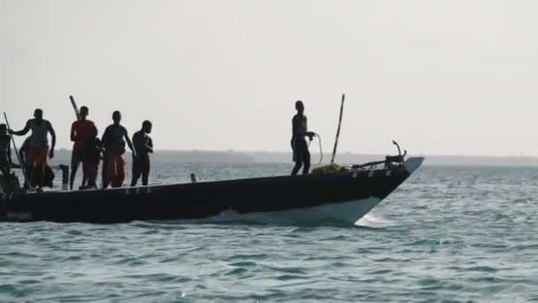 Lustige tanzende afrikanische Fischer auf einem hölzernen Motorboot, das im Ozean treibt, Afrika — Stockvideo