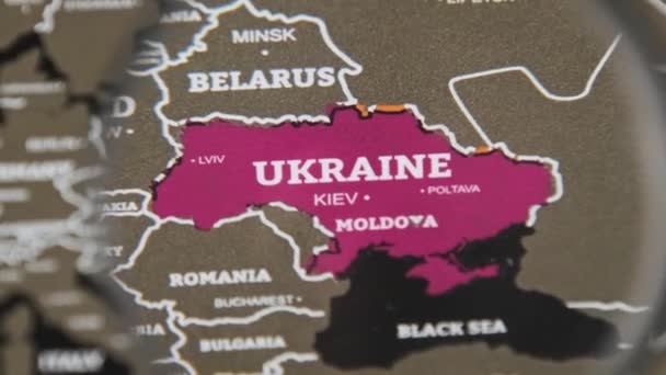 Ukraine on the World Map Under a Magnifier Loupe, Worldwide Attention to War — Stock Video