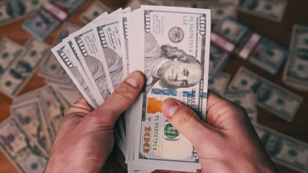 Dollari in mani maschili sullo sfondo della tavola con denaro, contando le banconote — Video Stock