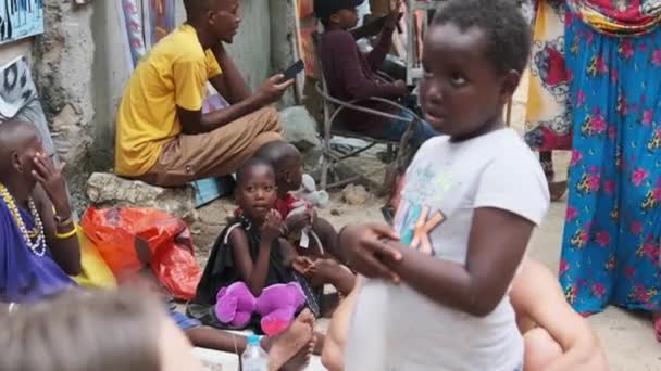 Crianças pequenas africanas famintas locais caminham na rua entre as pessoas, Zanzibar — Vídeo de Stock