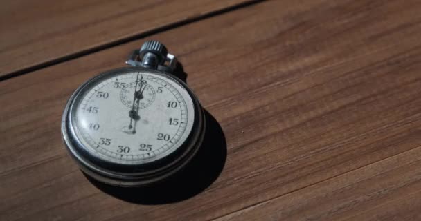 Μια αντίκα χρονόμετρο βρίσκεται στο ξύλινο τραπέζι και μετρά τα δευτερόλεπτα — Αρχείο Βίντεο