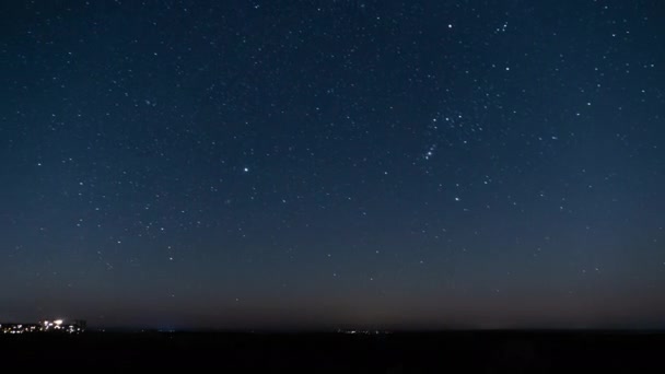 Зоряне небо в нічний час обертається над горизонтом поблизу міста Тімелапс. — стокове відео