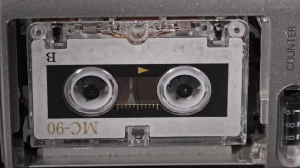 Cinta de audio vintage con una etiqueta en blanco girando en la grabadora de cassette, primer plano — Vídeo de stock