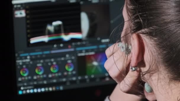 Mujer editor de vídeo se sienta en un ordenador portátil y los procesos de material de vídeo en casa — Vídeos de Stock
