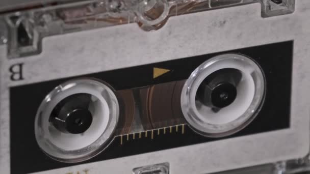 Cinta de audio vintage con una etiqueta en blanco girando en la grabadora de cassette, primer plano — Vídeos de Stock