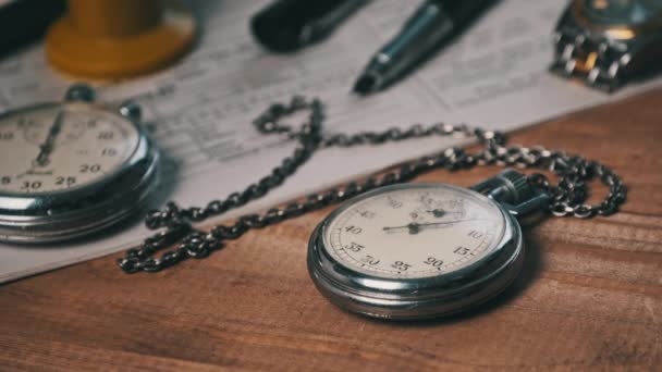 Chronomètre antique repose sur un bureau en bois avec de vieux documents et compte secondes — Video