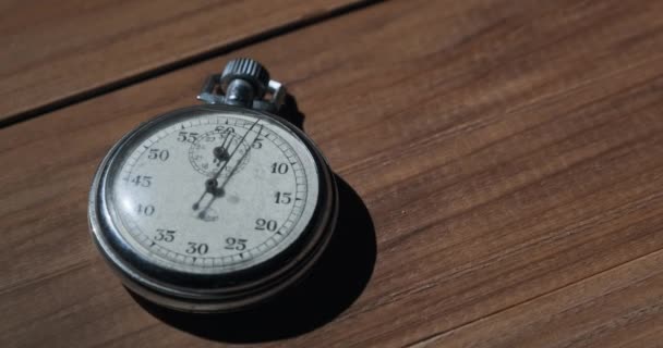 Un antico cronometro giace sul tavolo di legno e conta i secondi — Video Stock