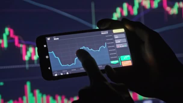 Investidor verificando Bitcoin Gráfico na tela do smartphone — Vídeo de Stock