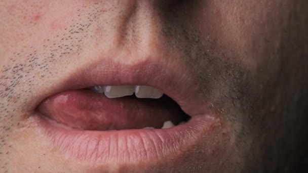 Muž si eroticky olizuje rty jazykem, zblízka — Stock video