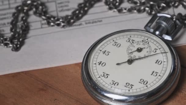 Vintage Stopwatch Lies on Wooden Desk with Old Documents and Counts Seconds — Stock Video