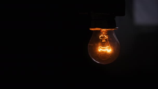 Glühbirne auf schwarzem Hintergrund langsam ein- und ausgeschaltet — Stockvideo