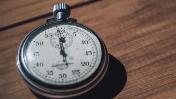 Een antieke stopwatch ligt op houten tafel en telt de seconden, Timelapse — Stockvideo