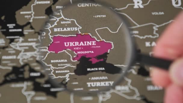 Ukraine på verdenskortet Under en forstørrelsesglas Loupe, Verdensomspændende opmærksomhed på krig – Stock-video