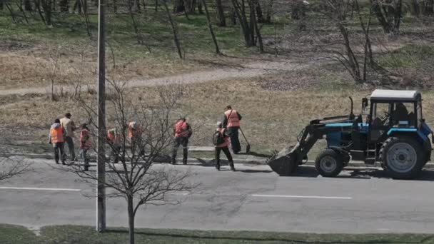 Trabajadores de la carretera limpian los lados de la carretera asfaltada — Vídeo de stock