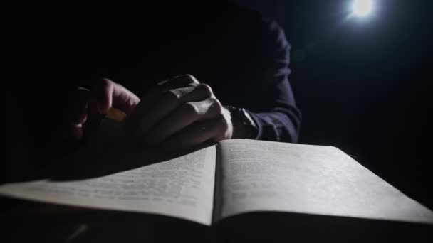 Читання старої книги під загадковим освітленням — стокове відео