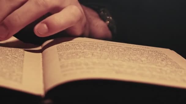 Lire un vieux livre sous l'éclairage de lampe jaune atmosphérique — Video