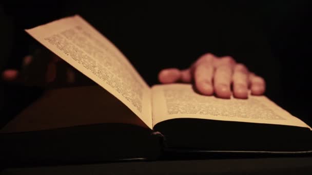 Het lezen van een oud boek onder atmosferische gele lamp verlichting — Stockvideo