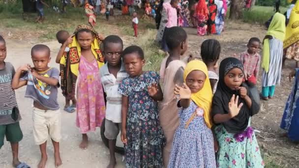 幸せな地元のアフリカの子供たち面白い手と好奇心旺盛な外見、ザンジバル村 — ストック動画