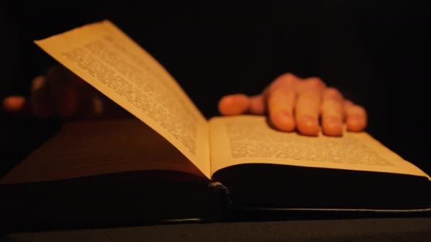 Lectura de un libro antiguo bajo iluminación de lámpara amarilla vintage — Vídeos de Stock