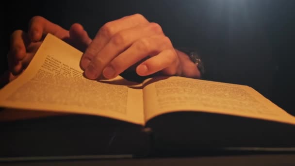 Het lezen van een oud boek onder atmosferische gele lamp verlichting — Stockvideo